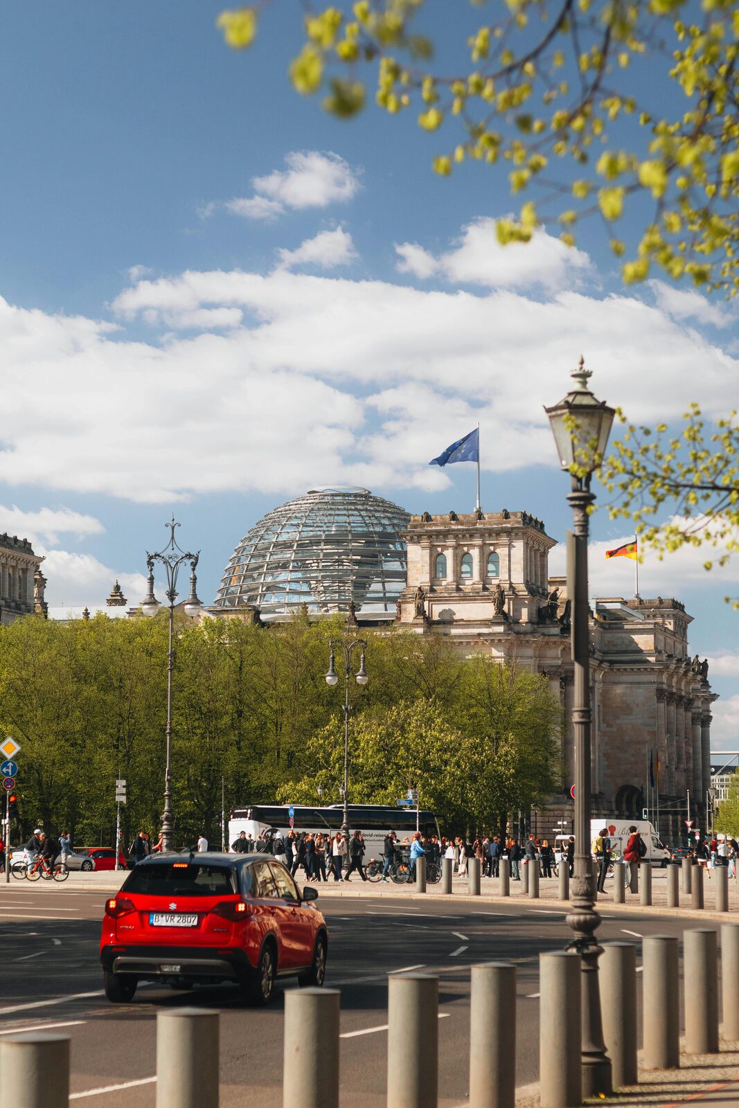 La cúpula de cristal del Reichstag entre árboles de otoño · Berlín