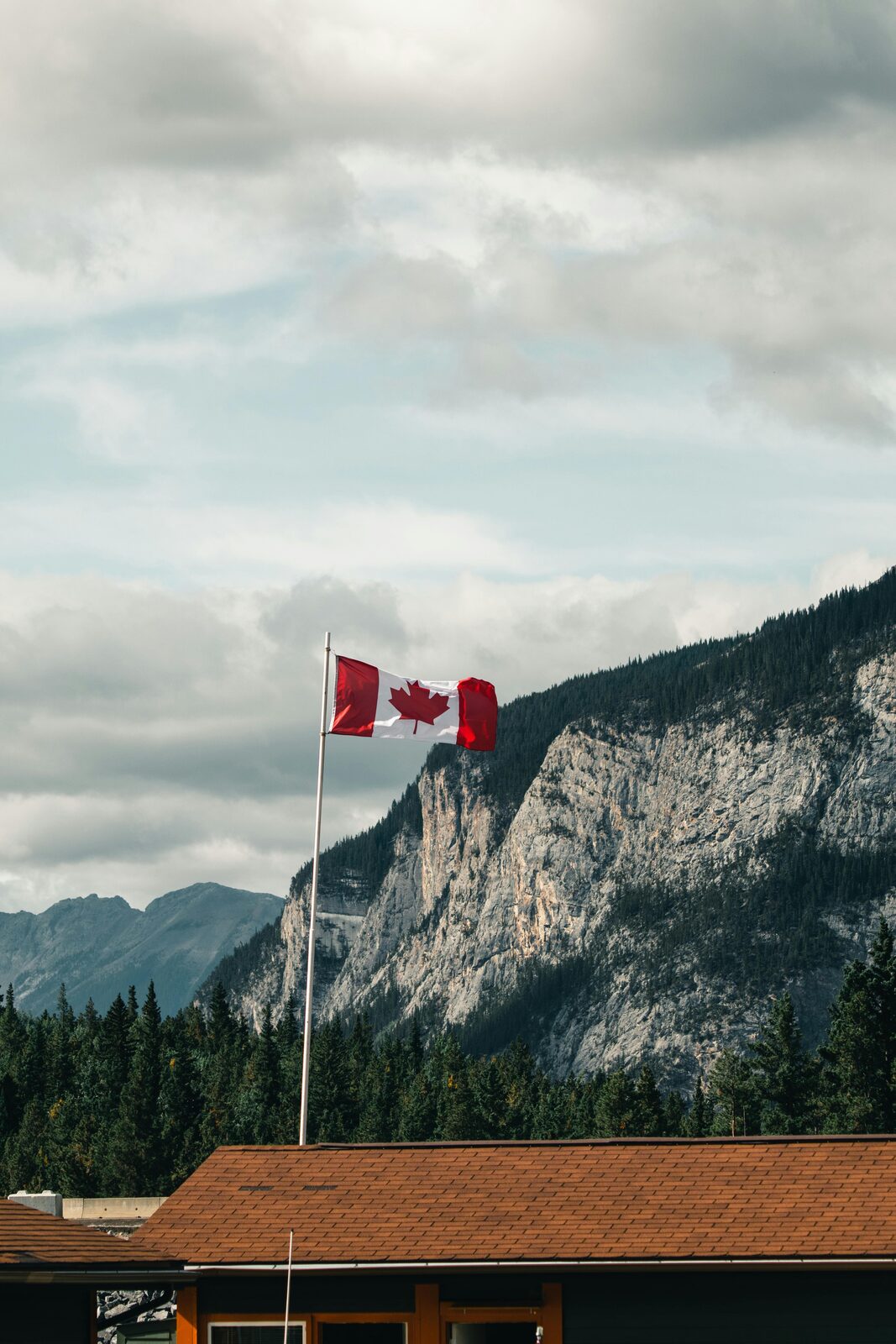 Bandera canadiense frente a una montaña de las Rocosas