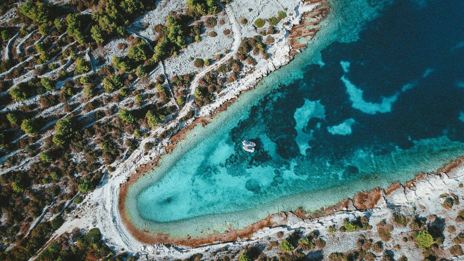 Cala de agua turquesa con un velero anclado en el Adriático croata