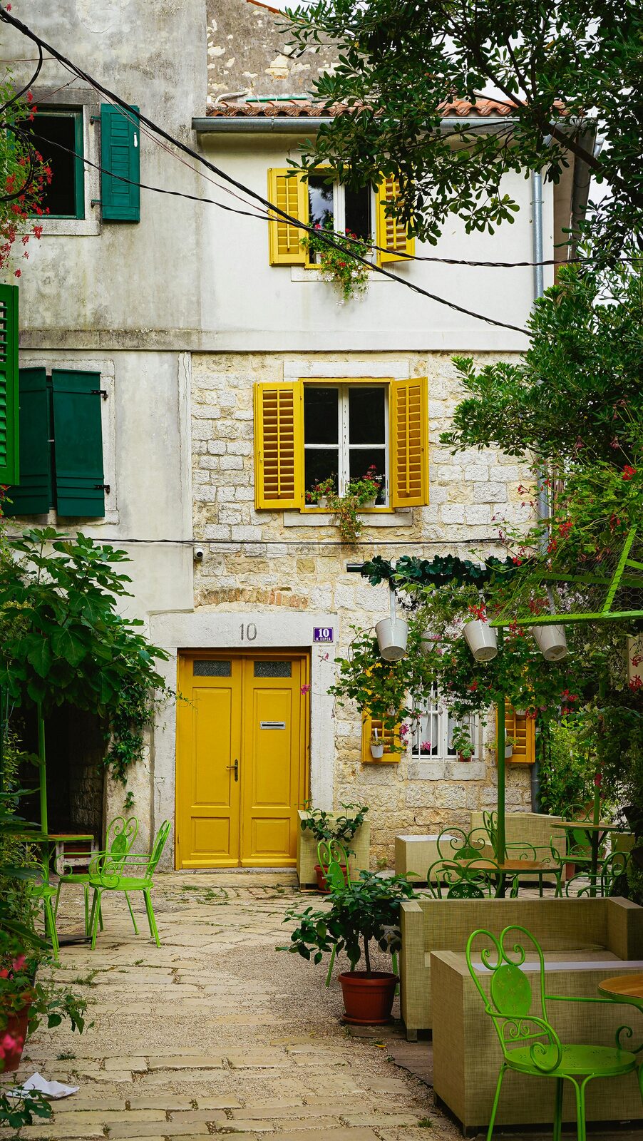 Patio istriano con puerta amarilla y mesas