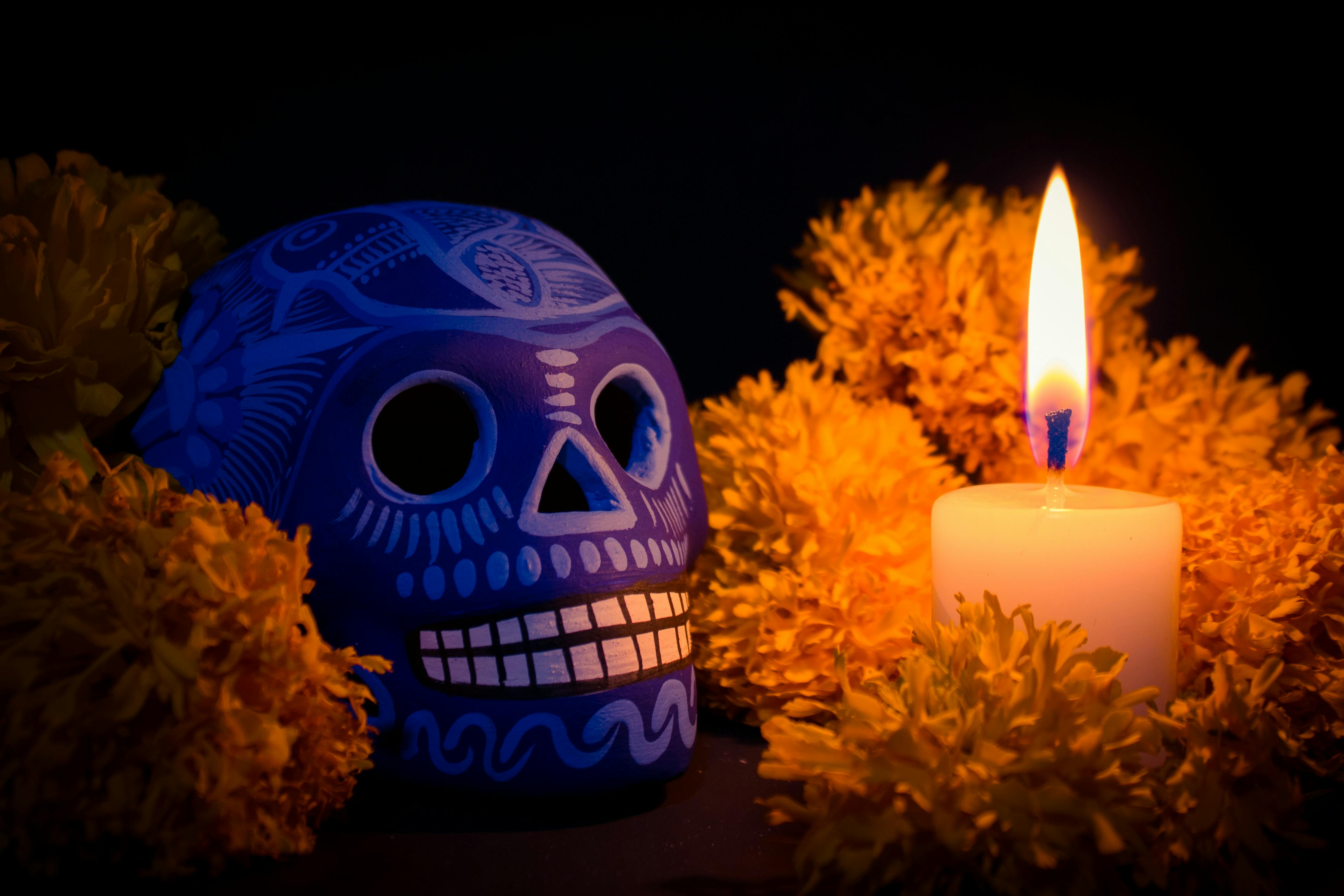 Mixquic, intact tradition with blue Talavera skull and candle among cempasúchil