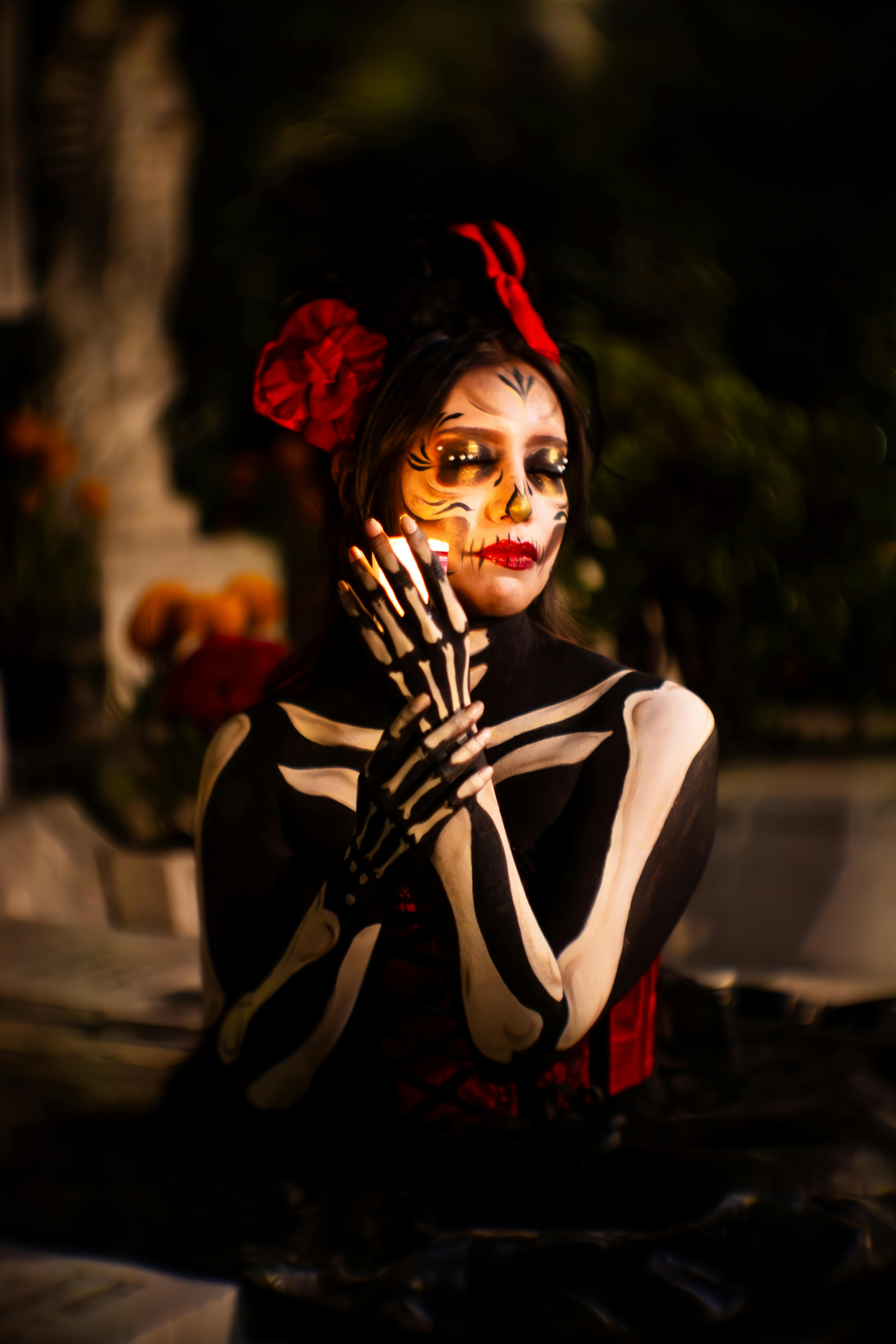Night of the Dead in Michoacán, Catrina with candle in an illuminated cemetery