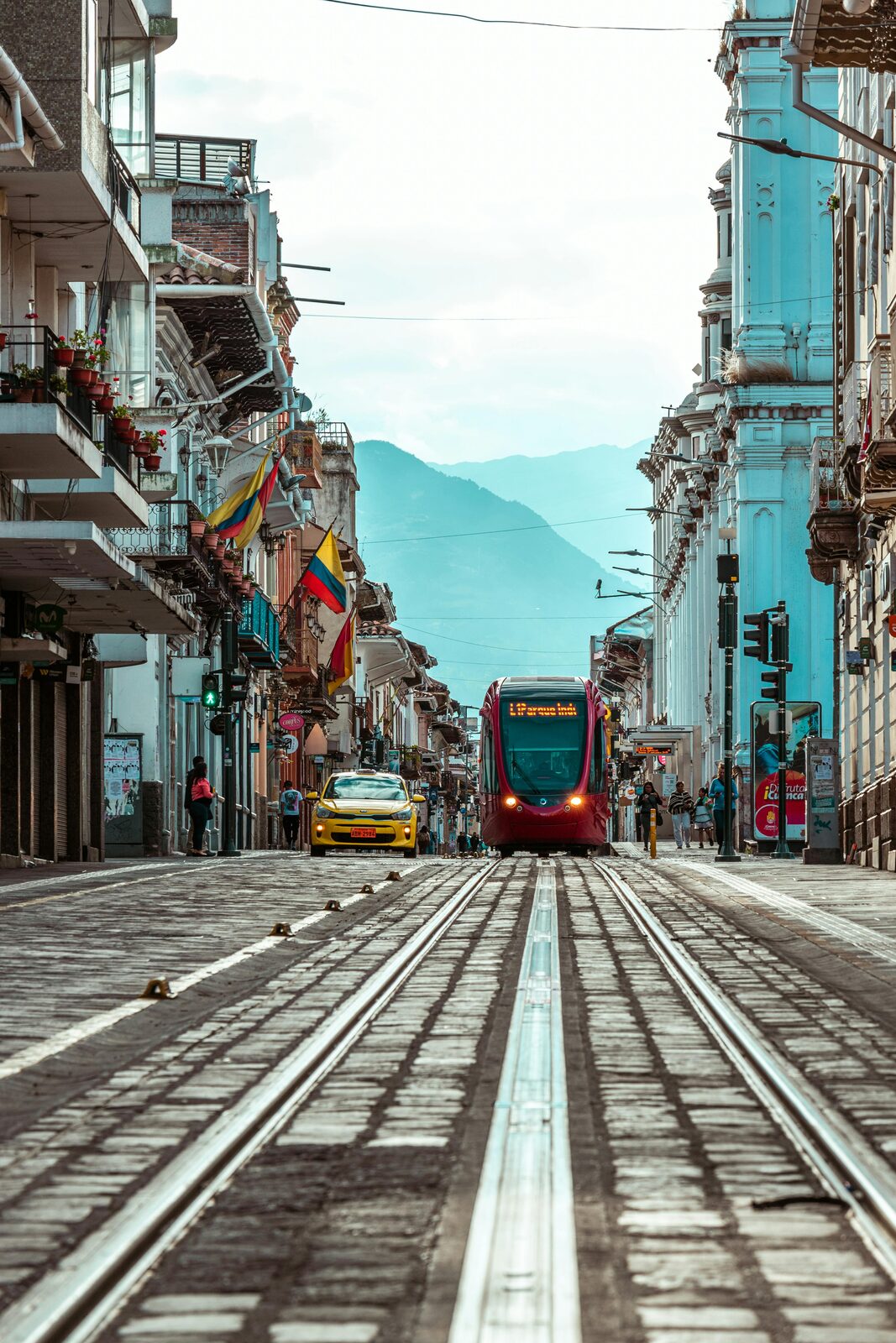 Calle de Cuenca con tranvía y banderas de Ecuador