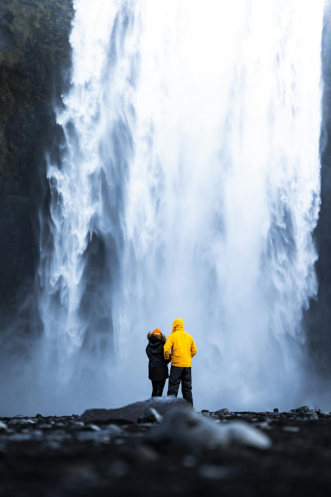 Pareja frente a la cascada Skógafoss en la costa sur de Islandia