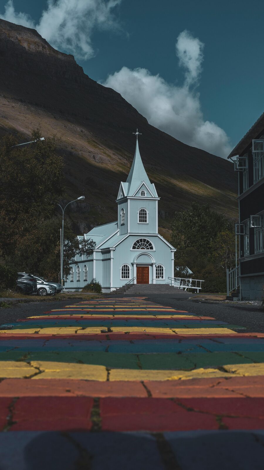 Iglesia azul de Seyðisfjörður con la calle del arcoíris