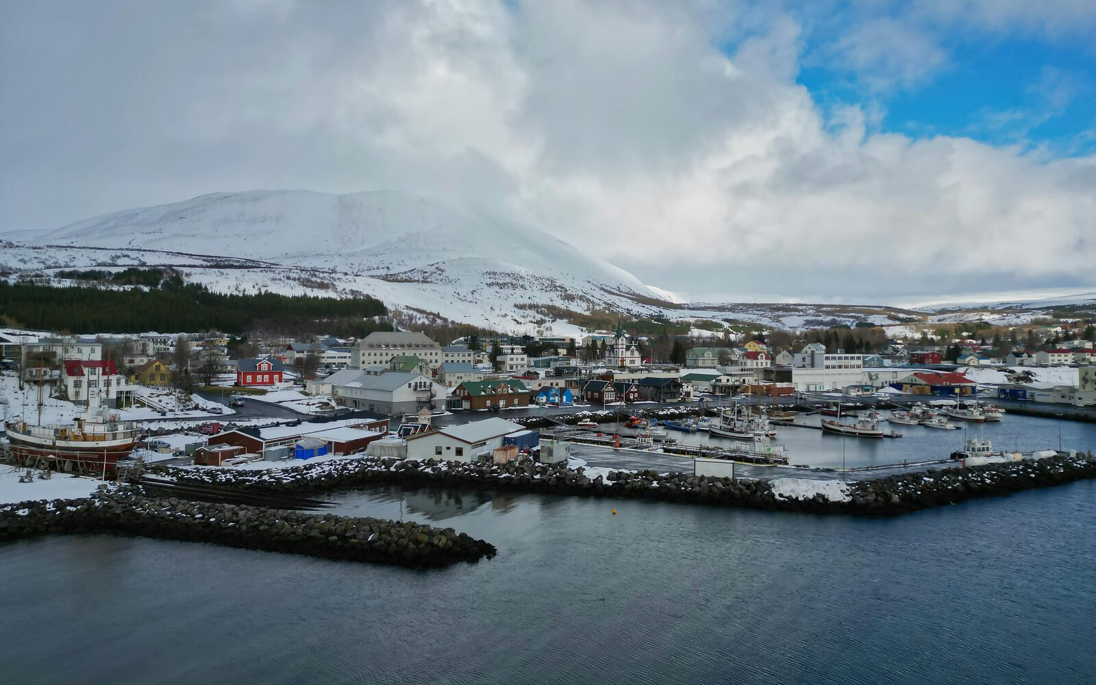 Pueblo del norte de Islandia frente al fiordo nevado