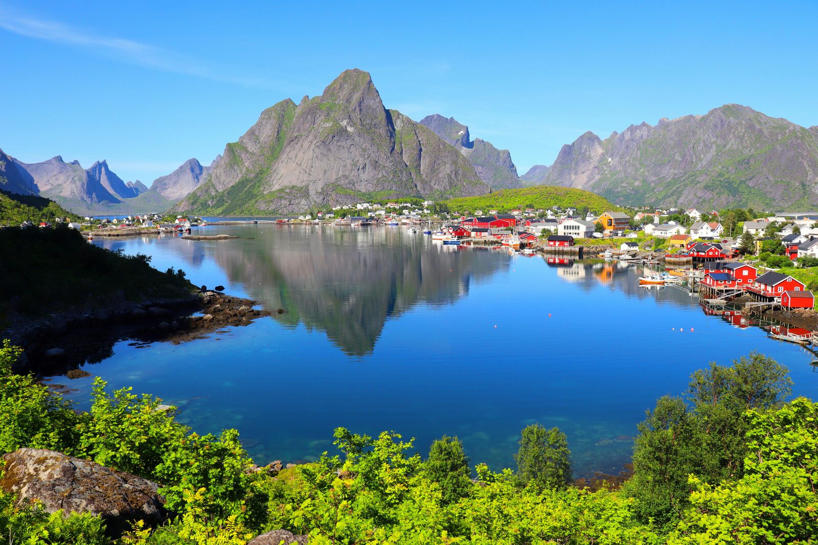 Pueblo de Reine en las islas Lofoten con montañas reflejadas en el agua
