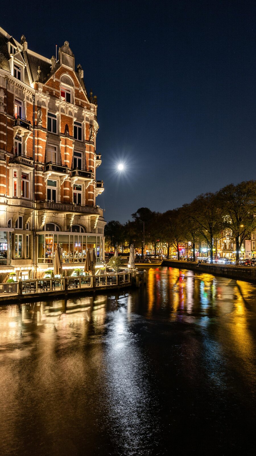 Edificio histórico iluminado reflejado en un canal de noche