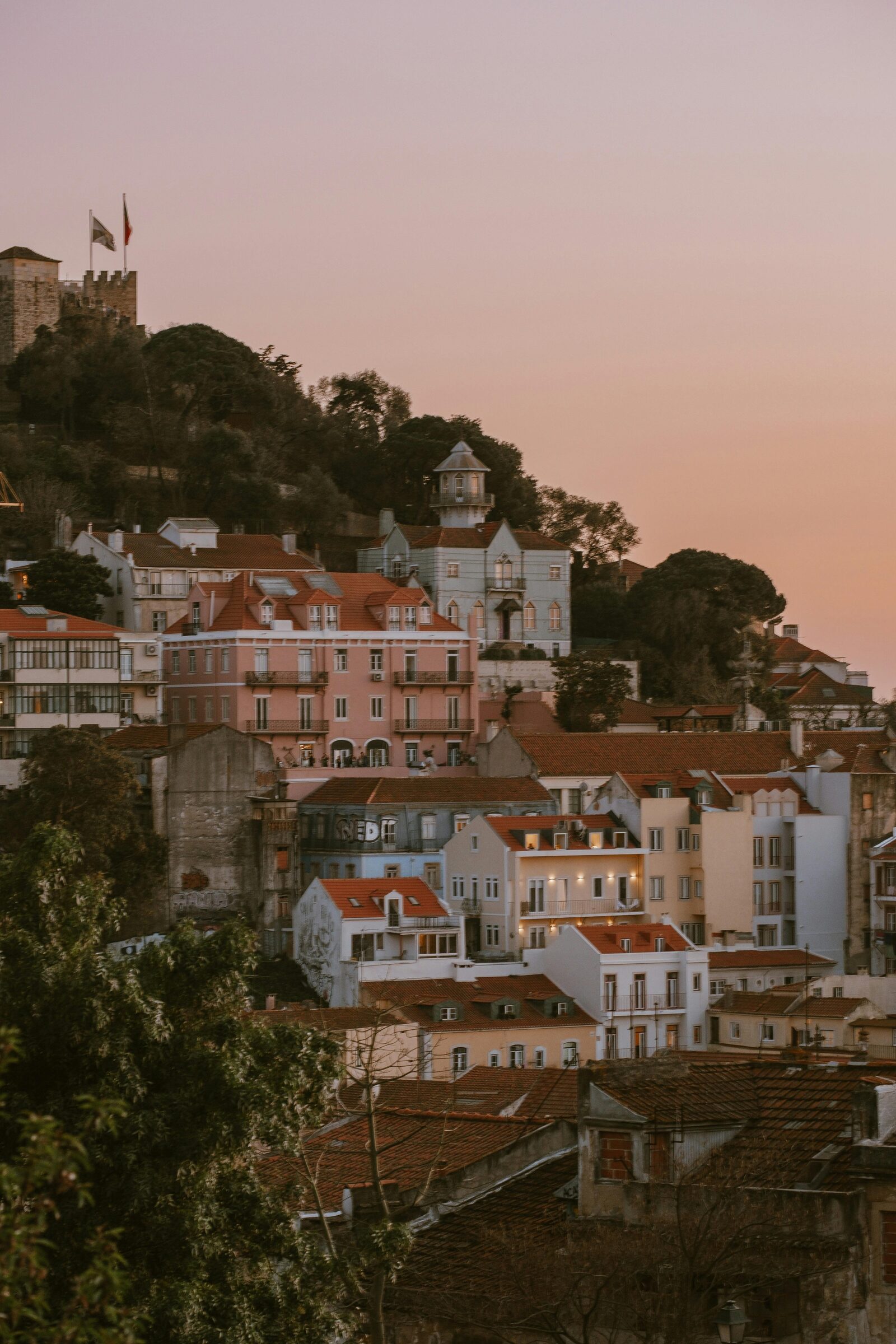 The hilltop of São Jorge castle above the Lisbon rooftops at sunset