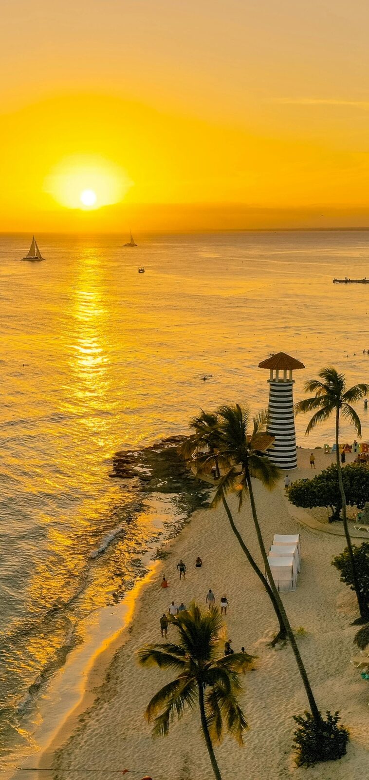 Atardecer sobre el mar con un faro en la costa dominicana
