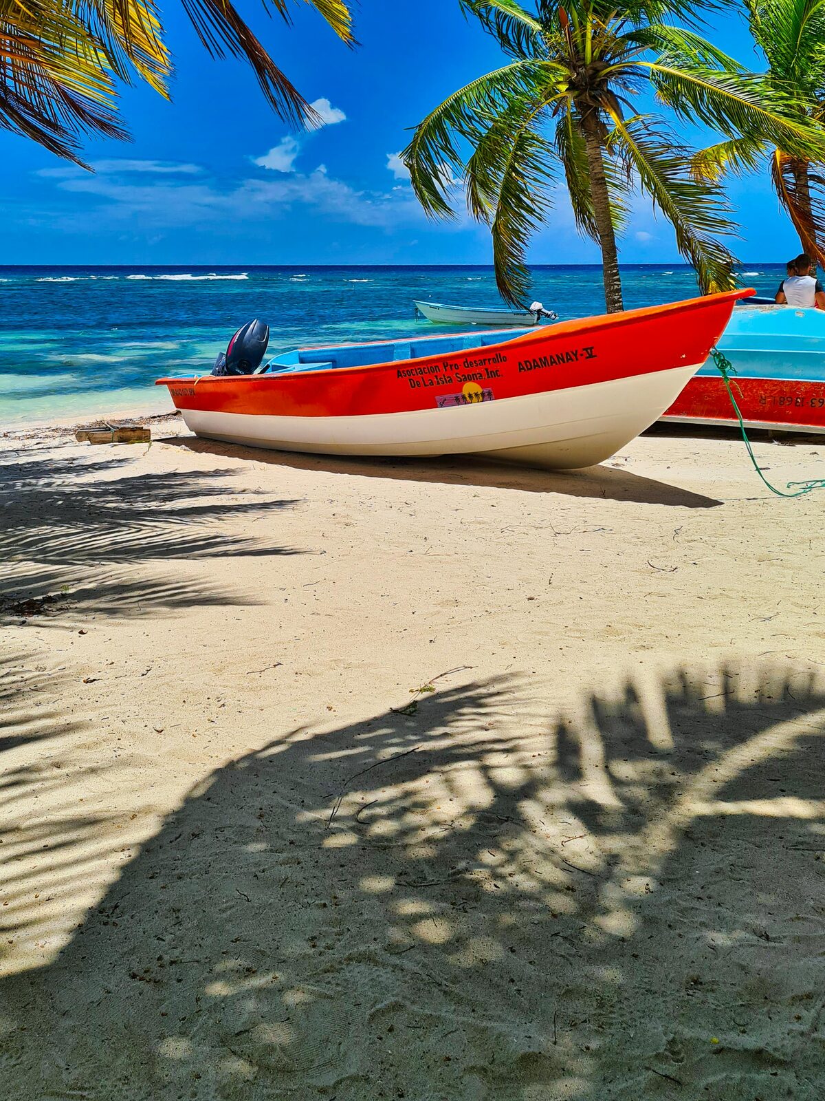 Bote rojo sobre la arena blanca de una playa dominicana