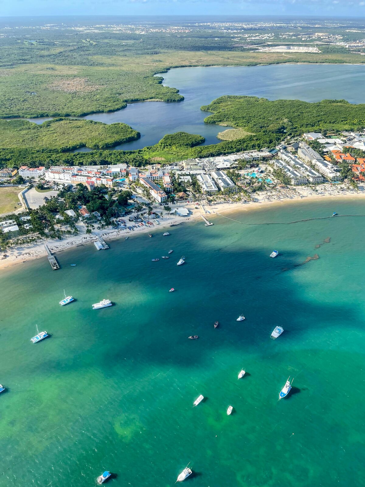 Vista aérea de una playa turquesa con botes en la costa de Punta Cana